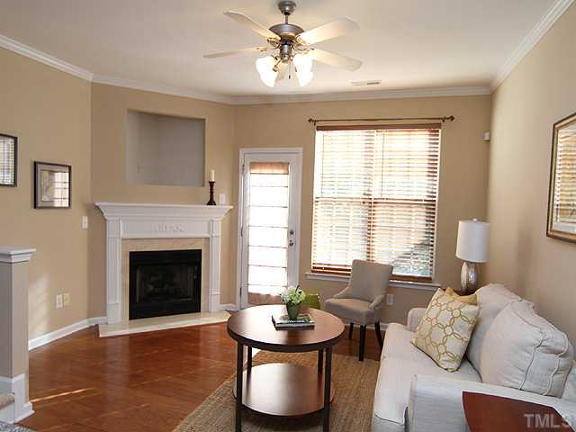 7843 Spungold Street Raleigh, NC 27617 - Photo 3 of 20 a living room with furniture a fireplace and a large window