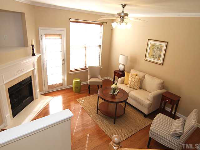 7843 Spungold Street Raleigh, NC 27617 - Photo 4 of 20 a living room with furniture a fireplace and a flat screen tv