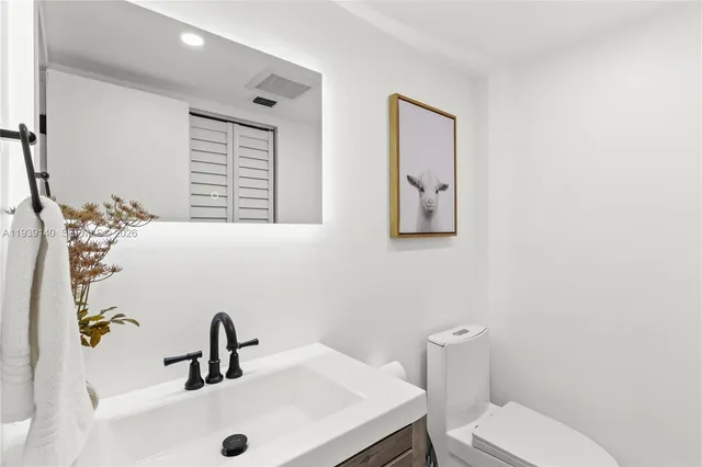 a bathroom with a sink mirror and toilet