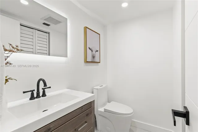 a bathroom with a sink a toilet and mirror