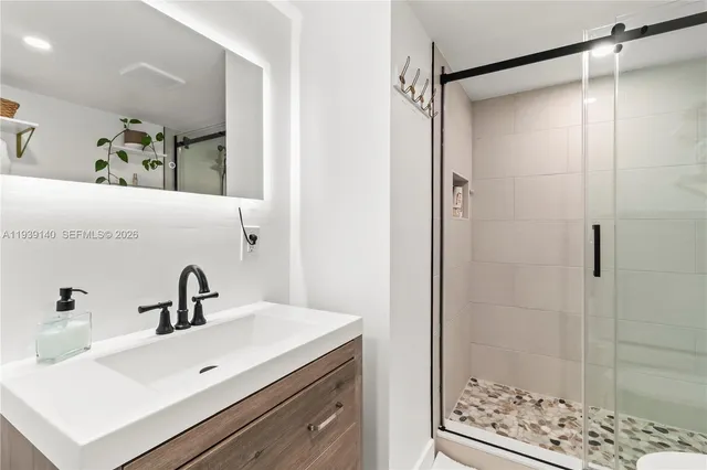 a bathroom with a sink mirror and shower