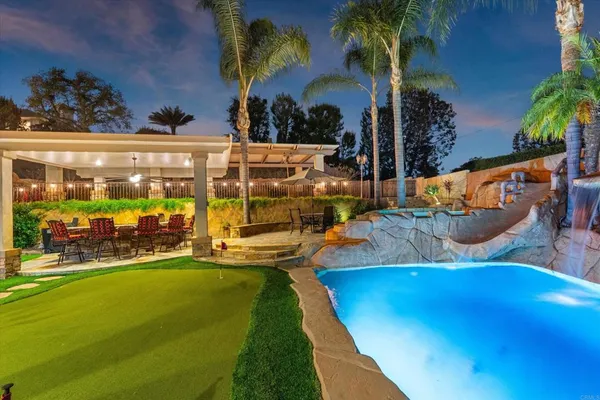 a view of a swimming pool with outdoor seating and a patio