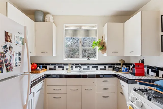 a kitchen with stainless steel appliances a sink a stove and a window