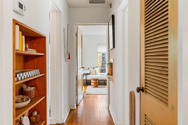 a view of a hallway with wooden floor windows and a livingroom