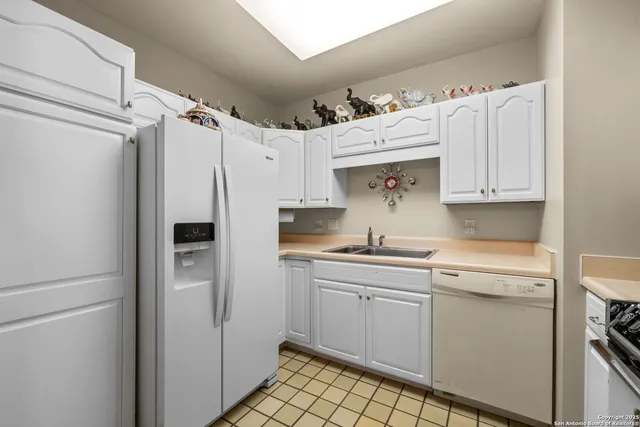 a kitchen with a sink a refrigerator and cabinets
