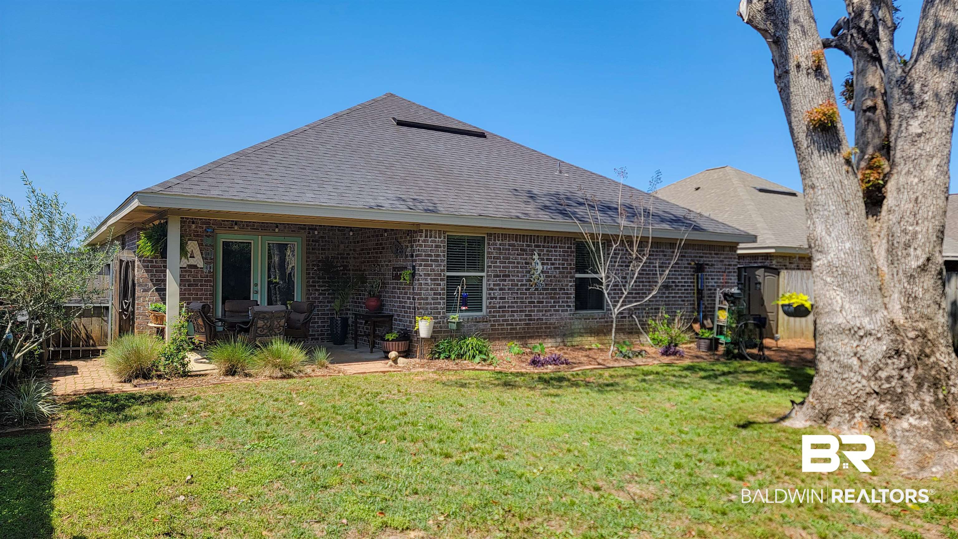 1304 Majesty Loop Foley, AL 36535 - Photo 33 of 44 Back of property with a shingled roof, brick siding, and a patio