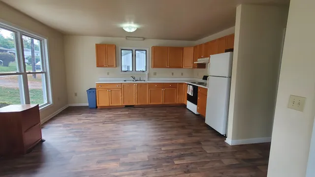 a large kitchen with a wooden floor and a large window