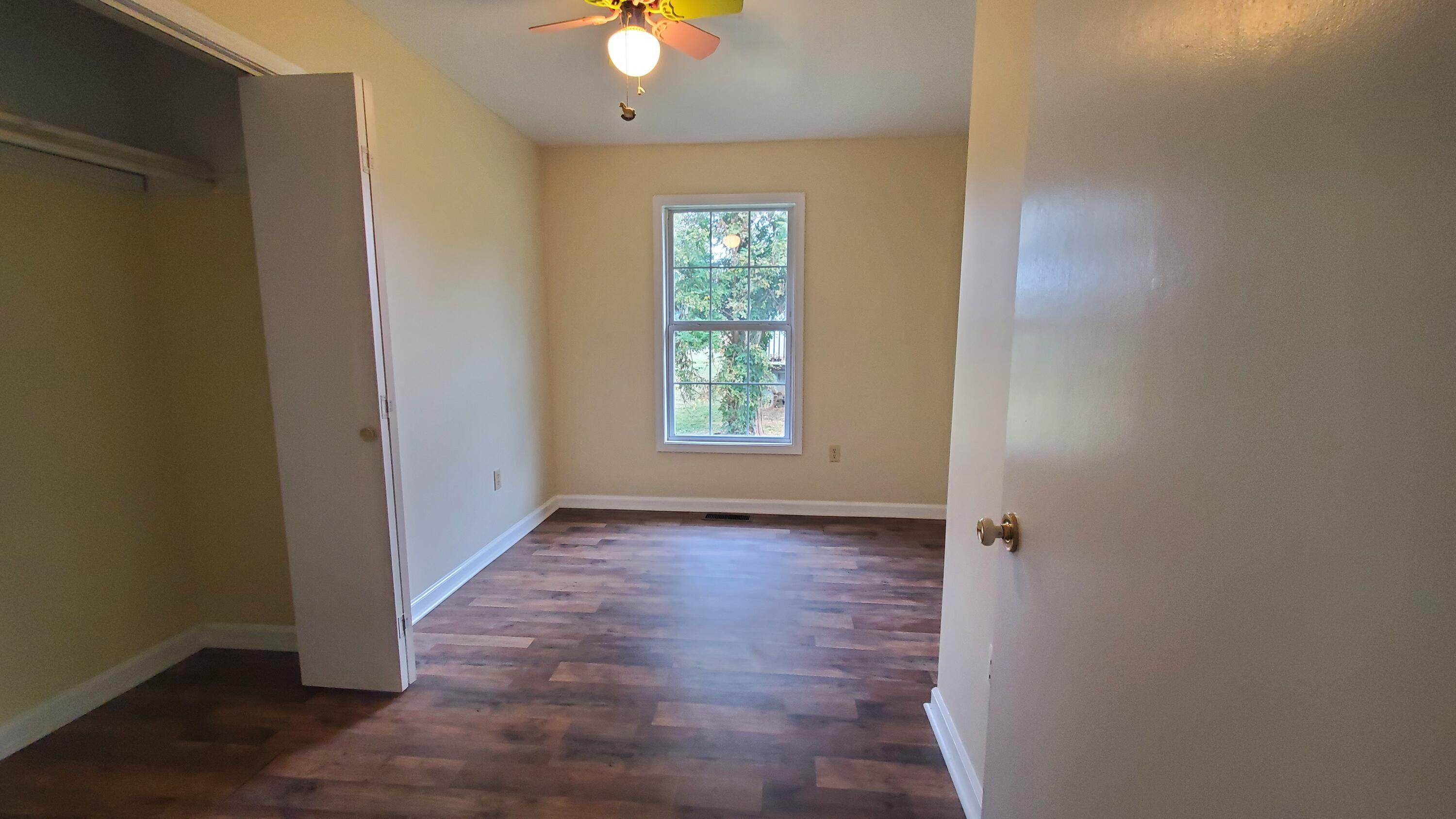80 Honeywood Road Rocky Mount, VA 24151 - Photo 8 of 18 an empty room with wooden floor and windows