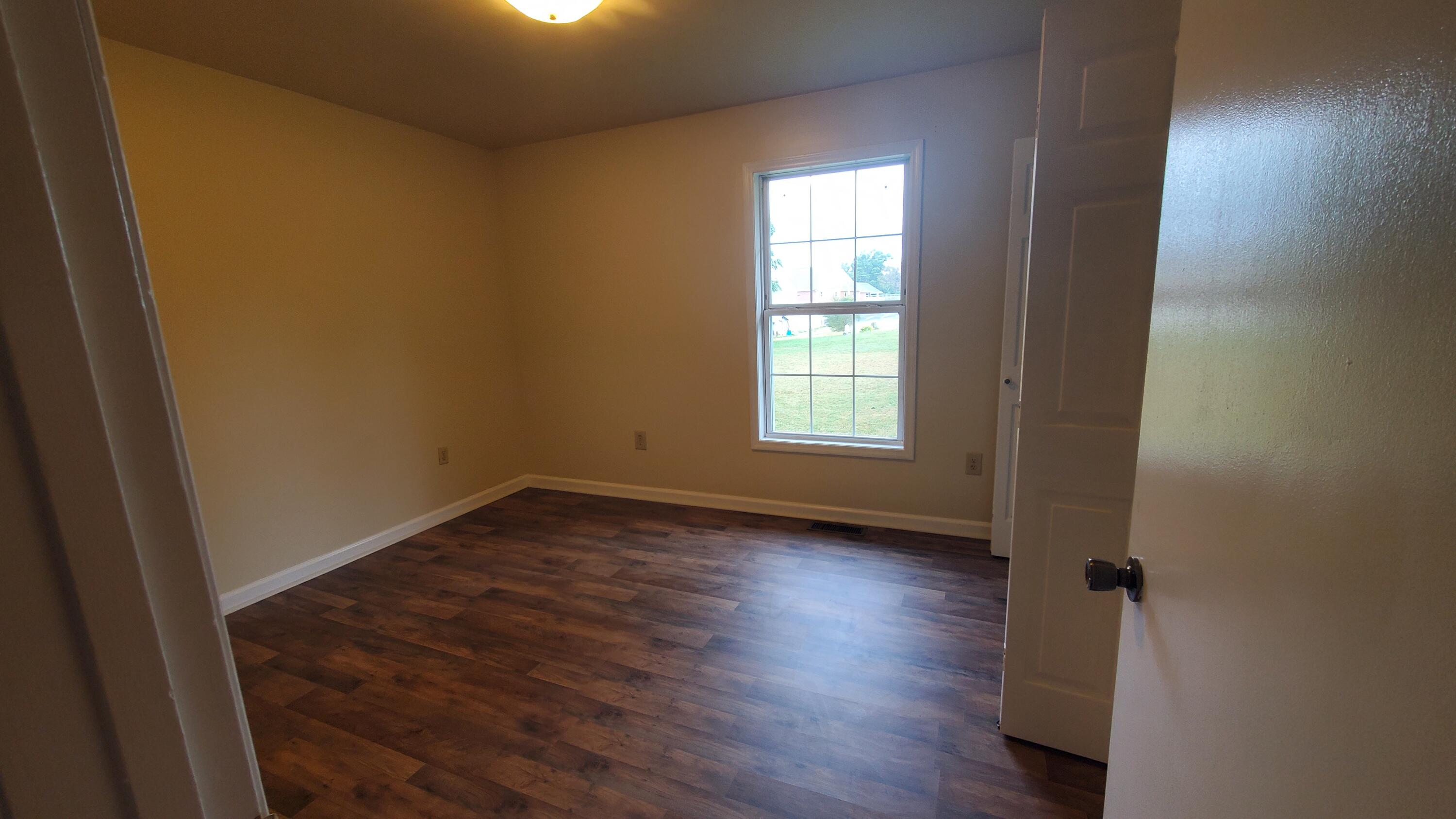 80 Honeywood Road Rocky Mount, VA 24151 - Photo 9 of 18 an empty room with wooden floor and windows