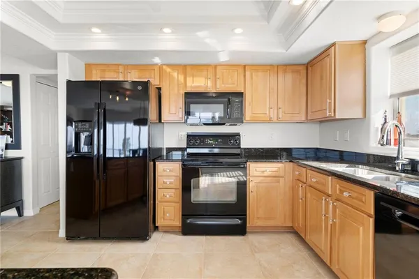 a kitchen with stainless steel appliances granite countertop a refrigerator and a stove top oven