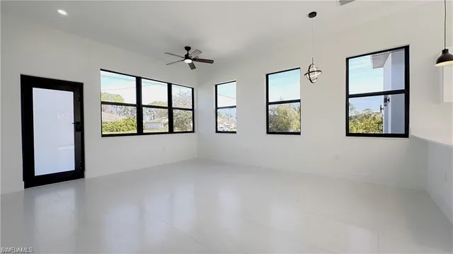 an empty room with windows and cabinet