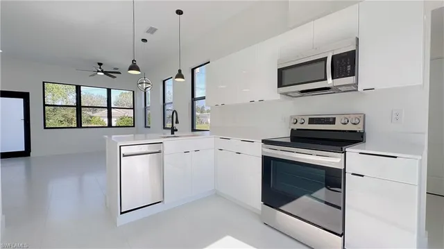 a kitchen with stainless steel appliances a stove sink microwave and cabinets