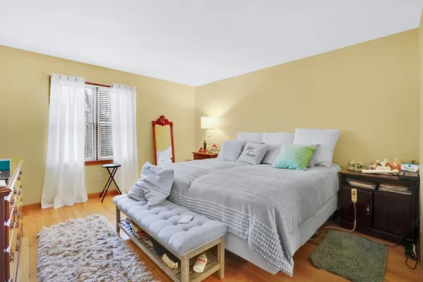 a spacious bedroom with a bed and wooden floor