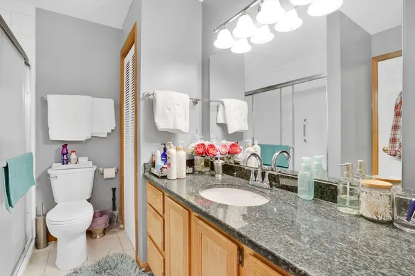 a bathroom with a granite countertop sink mirror and toilet