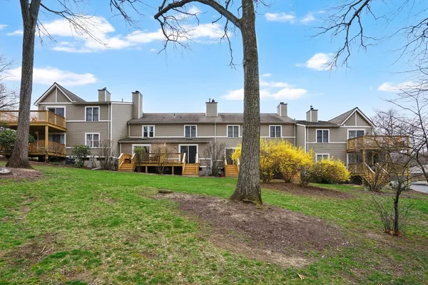 a view of a big house with a big yard and large tree