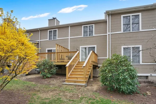 a view of a house with a small yard and wooden fence