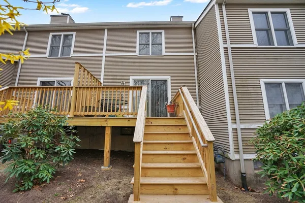 a view of a house with wooden fence and a stairs