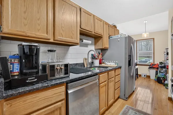 a kitchen with stainless steel appliances granite countertop a sink refrigerator and cabinets