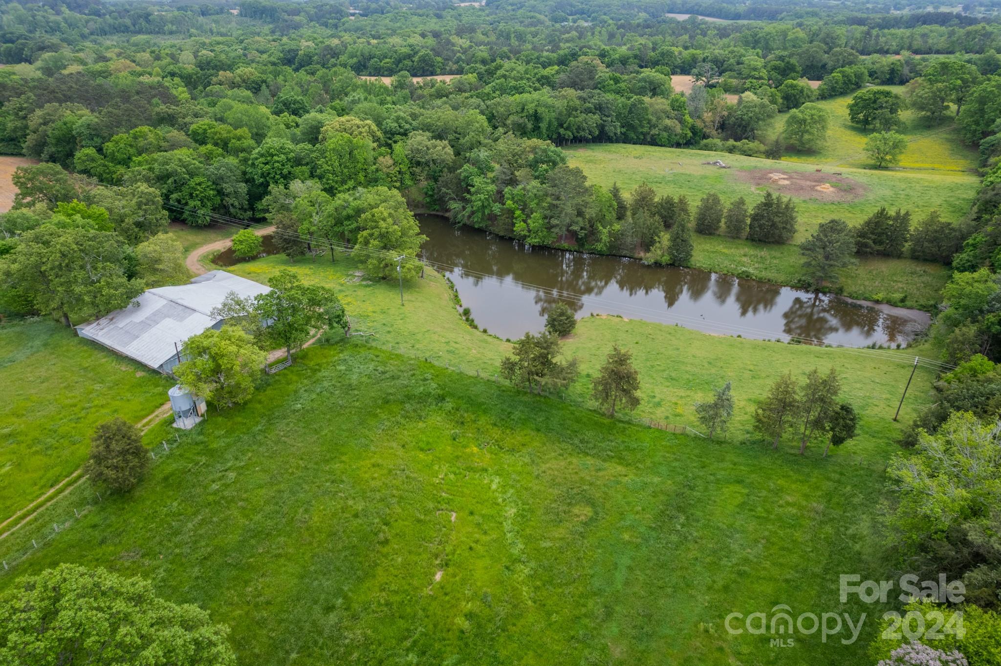 24686 Barbees Grove Road Oakboro, NC 28129 - Photo 29 of 35 an aerial view of green landscape with trees houses and lake view