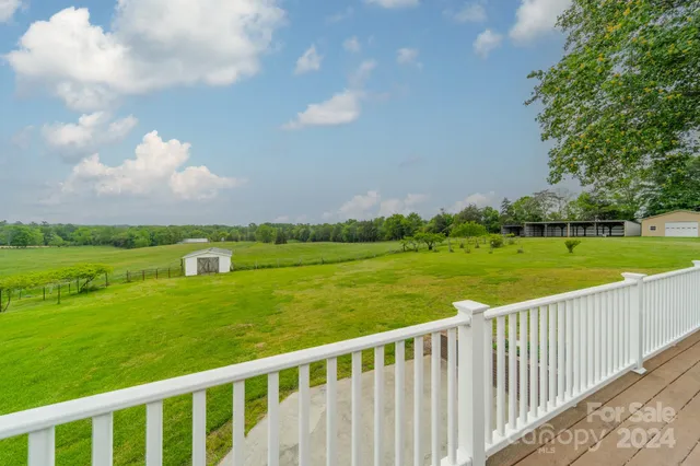 a view of a green field with sitting in the background