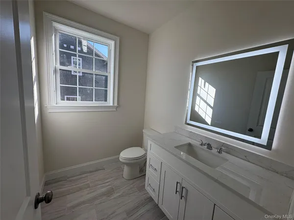 a bathroom with a toilet sink and mirror