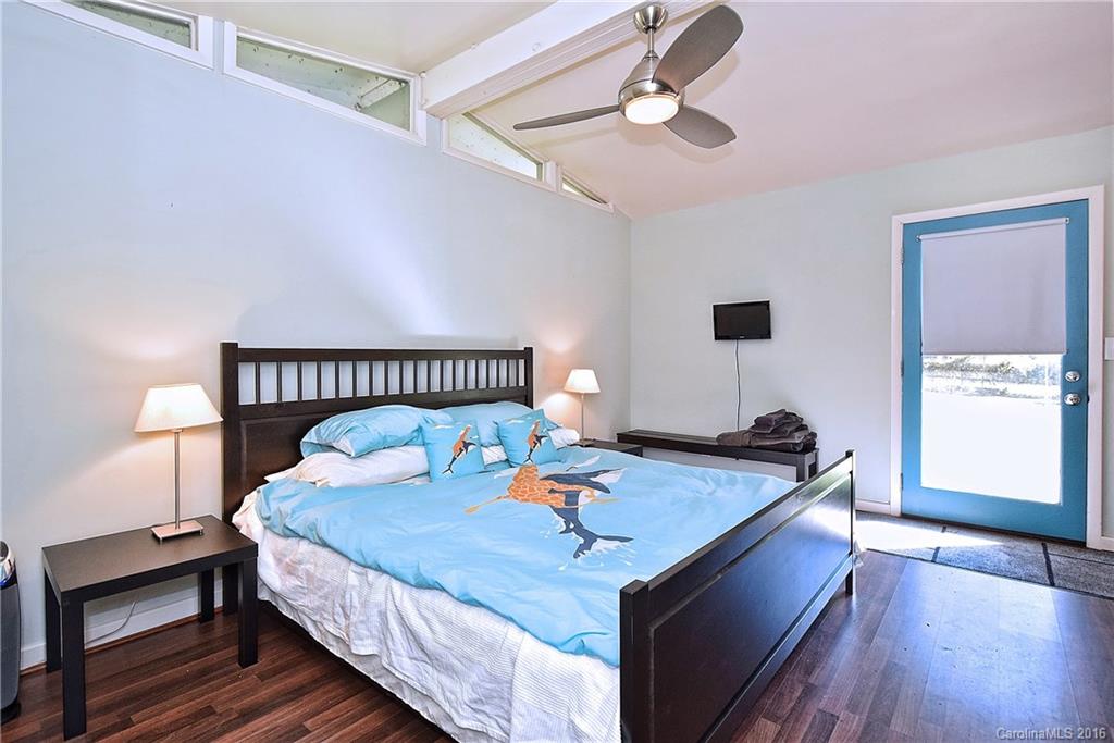 3111 Spring Valley Road Charlotte, NC 28210 - Photo 22 of 24 a bed sitting in a bedroom next to a window with a chandelier