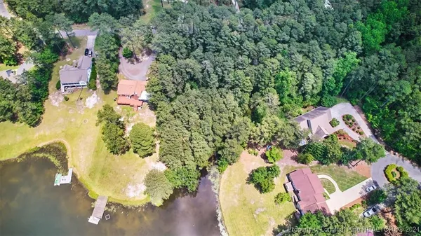 an aerial view of a house with a yard and lake view