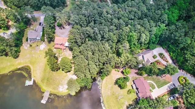 an aerial view of a house with a yard and lake view