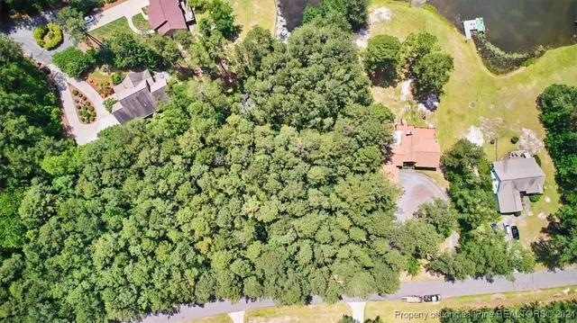 an aerial view of residential house with outdoor space and trees all around