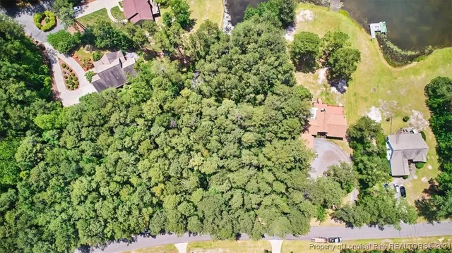 an aerial view of residential house with outdoor space and trees all around