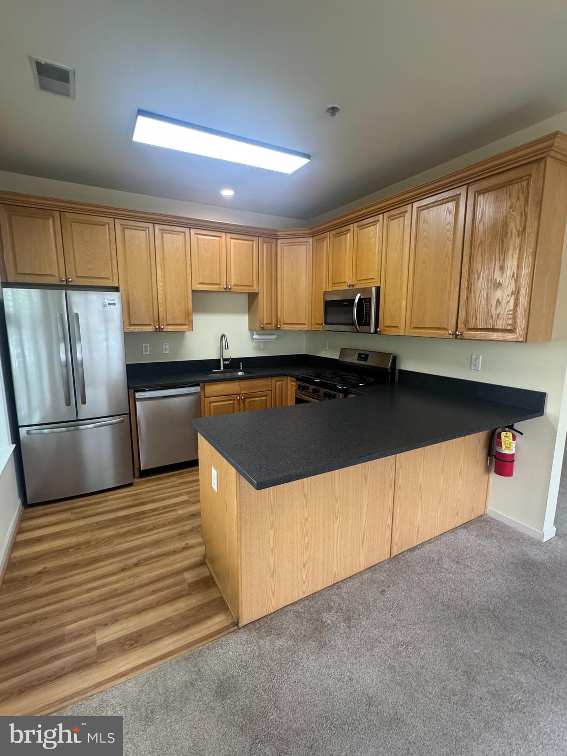 113 Kyle Way Ewing, NJ 08628 - Photo 21 of 25 a kitchen with stainless steel appliances granite countertop a stove a sink dishwasher a refrigerator and a microwave oven with wooden floor