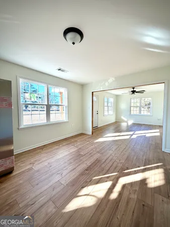a view of empty room with wooden floor and fan