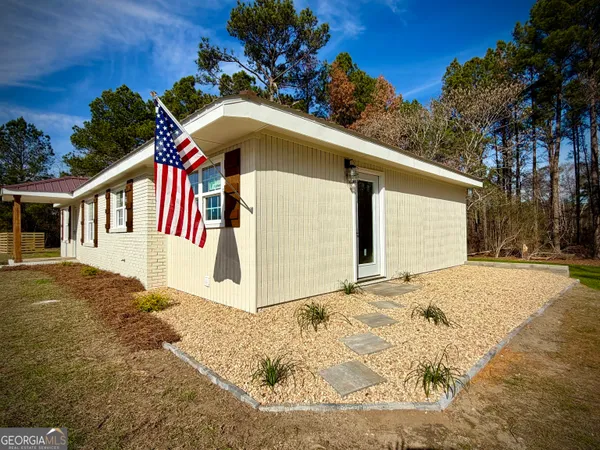 a view of a white house with a yard