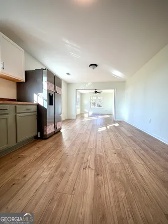 a view of empty room with wooden floor and window