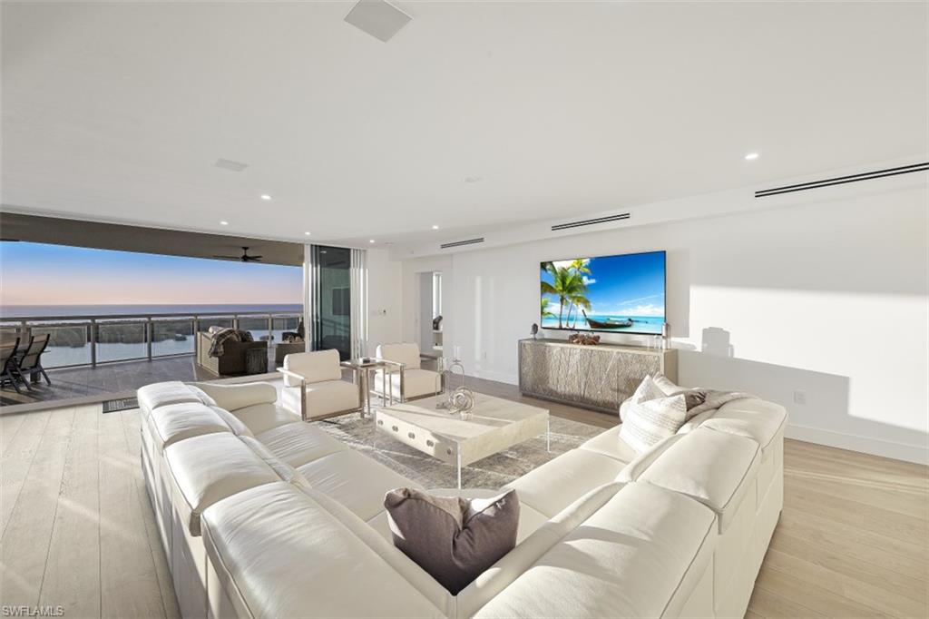 13935 Old Coast Road, Unit 1703 Naples, FL 34110 - Photo 3 of 44 a living room with furniture a fireplace and a flat screen tv