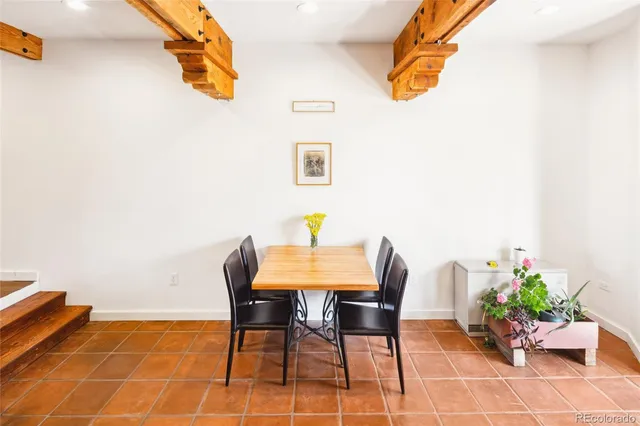 a dining room with furniture and a potted plant
