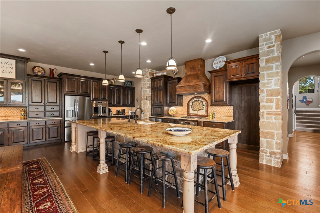 1039 Bluewater Place Spring Branch, TX 78070 - Photo 24 of 48 a view of a dining room and livingroom with furniture wooden floor a rug a fireplace and a chandelier