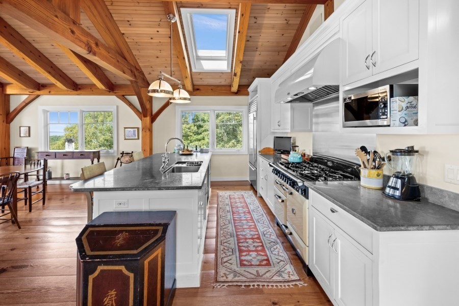 97 Longview Road West Tisbury, MA 02568 - Photo 18 of 42 a kitchen with stainless steel appliances granite countertop a stove a sink dishwasher and white cabinets with wooden floor