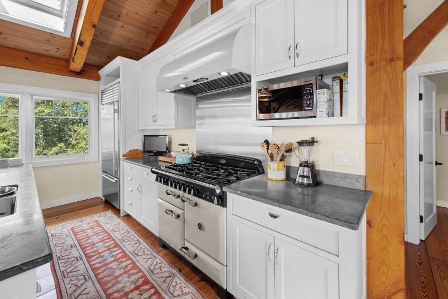 97 Longview Road West Tisbury, MA 02568 - Photo 19 of 42 a kitchen with stainless steel appliances granite countertop a stove and a microwave