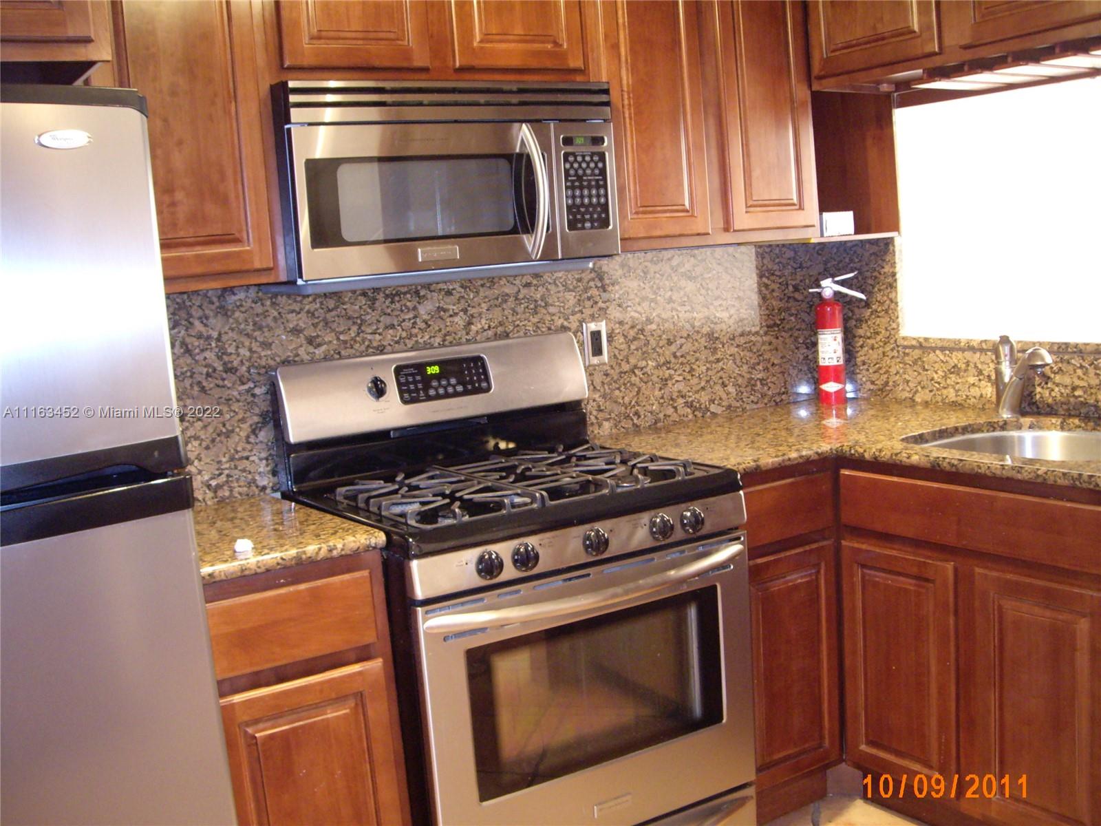 a kitchen with stainless steel appliances granite countertop a stove and a microwave