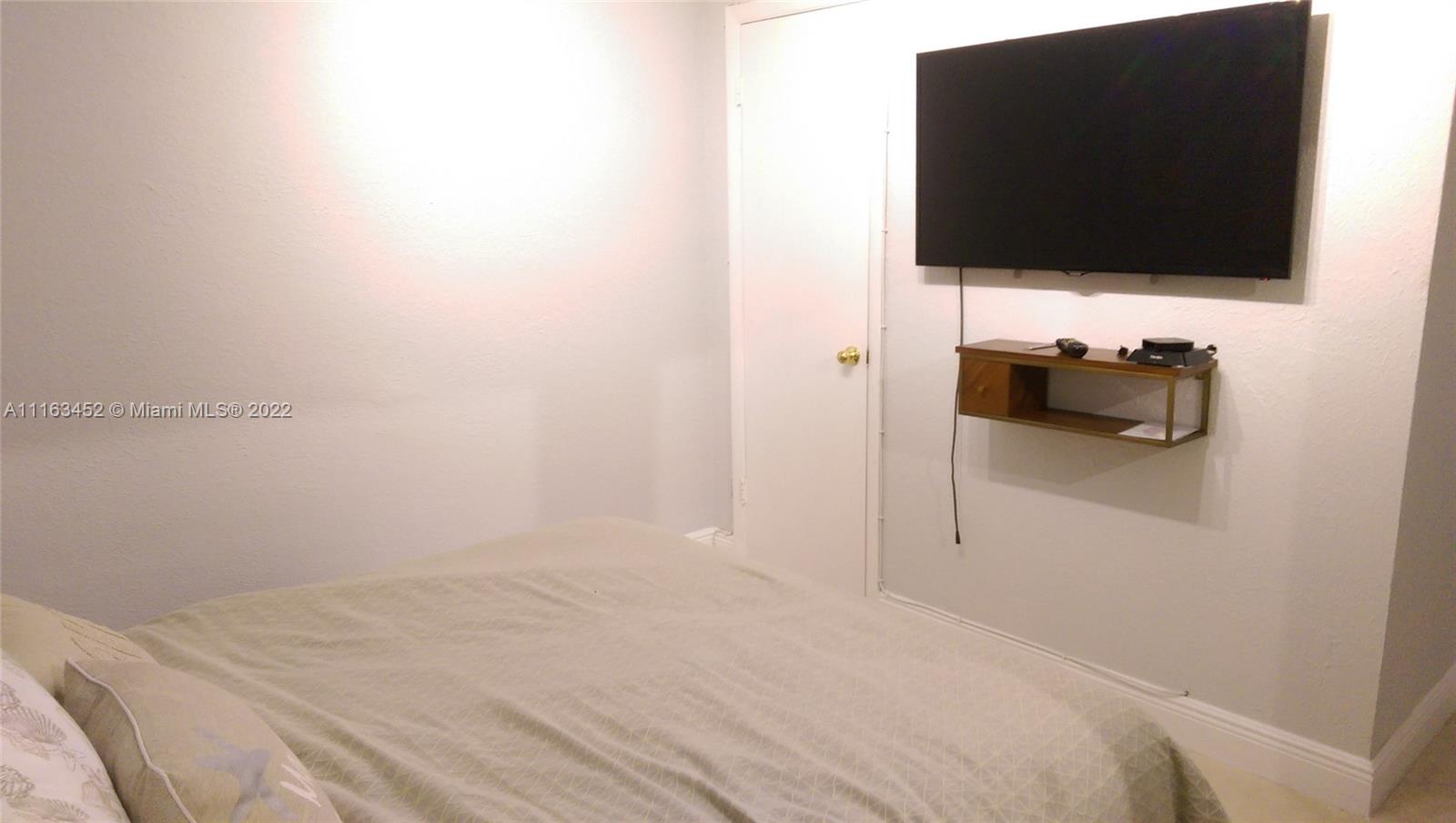 6709 North Kendall Drive, Unit 219 Pinecrest, FL 33156 - Photo 12 of 17 a bedroom with a bed and a flat screen tv