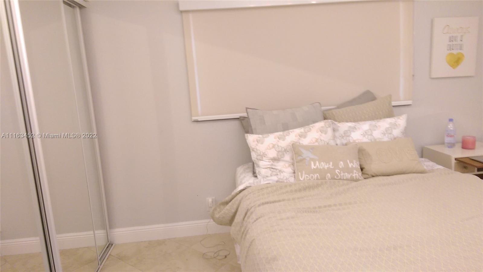 6709 North Kendall Drive, Unit 219 Pinecrest, FL 33156 - Photo 13 of 17 a bedroom with a bed and a mirror