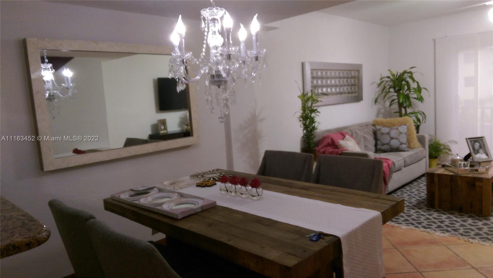 6709 North Kendall Drive, Unit 219 Pinecrest, FL 33156 - Photo 5 of 17 a living room with furniture and a chandelier