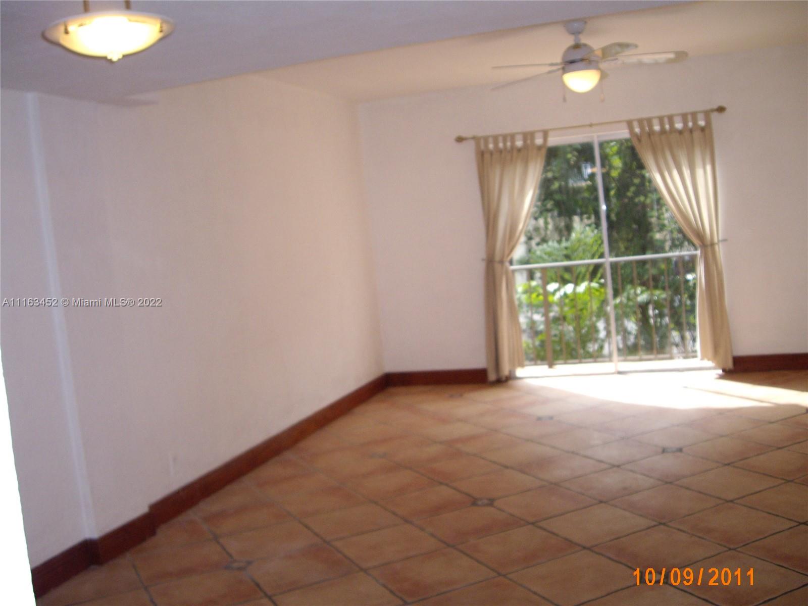 6709 North Kendall Drive, Unit 219 Pinecrest, FL 33156 - Photo 8 of 17 a view of an empty room with wooden floor and a window
