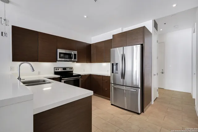 a kitchen with a refrigerator a microwave a sink and cabinets