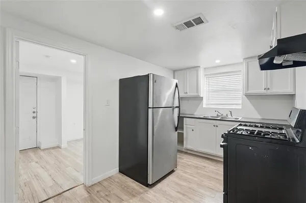 a kitchen with a refrigerator and a stove top oven