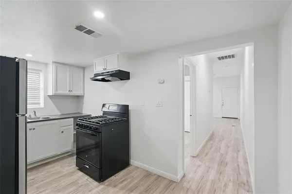 a kitchen with granite countertop a stove and a refrigerator