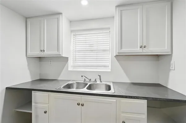 a kitchen with granite countertop white cabinets and a sink