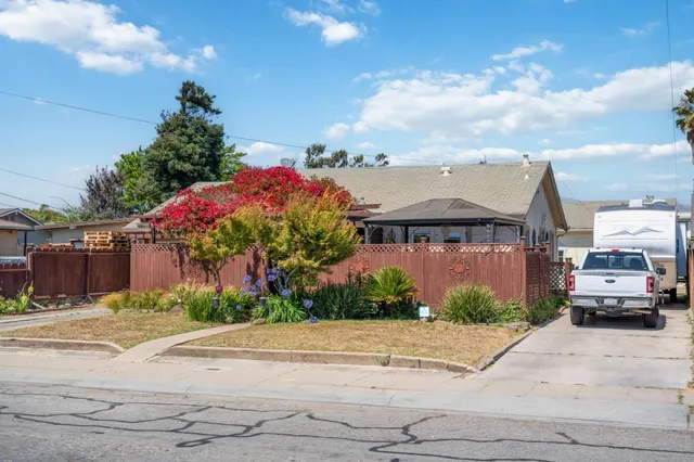 a front view of a house with a yard and a car park