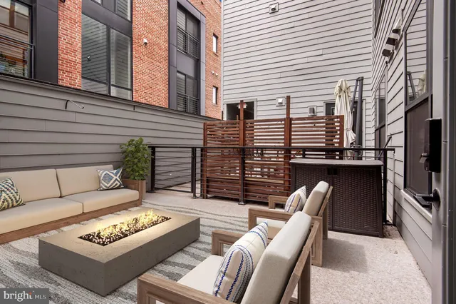 a view of a patio with couches chairs and a flat tv screen on the deck